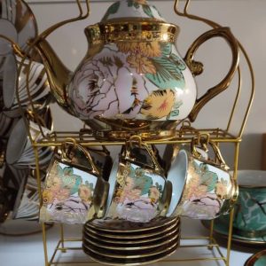 Juego de té de porcelana con un diseño floral y detalles dorado