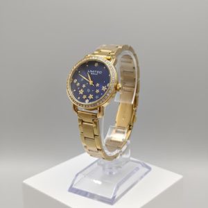 Reloj de metal en tono dorado con una esfera azul oscuro con estrellas.