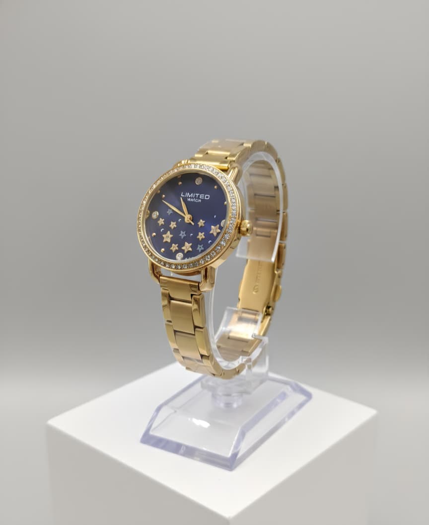 Reloj de metal en tono dorado con una esfera azul oscuro con estrellas.